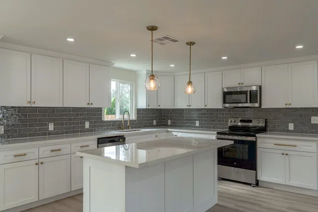 a kitchen with a sink a stove a microwave and cabinets