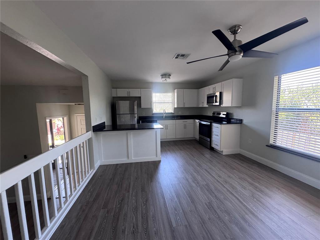 1755 Highland Road Osprey, FL 34229 - Photo 12 of 31 a kitchen with stainless steel appliances granite countertop a refrigerator a stove top oven a sink dishwasher and white cabinets with wooden floor
