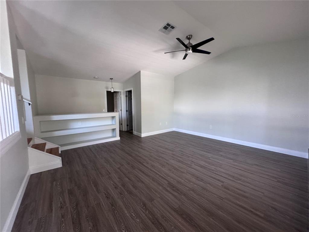 1755 Highland Road Osprey, FL 34229 - Photo 2 of 31 an empty room with wooden floor a ceiling fan and windows