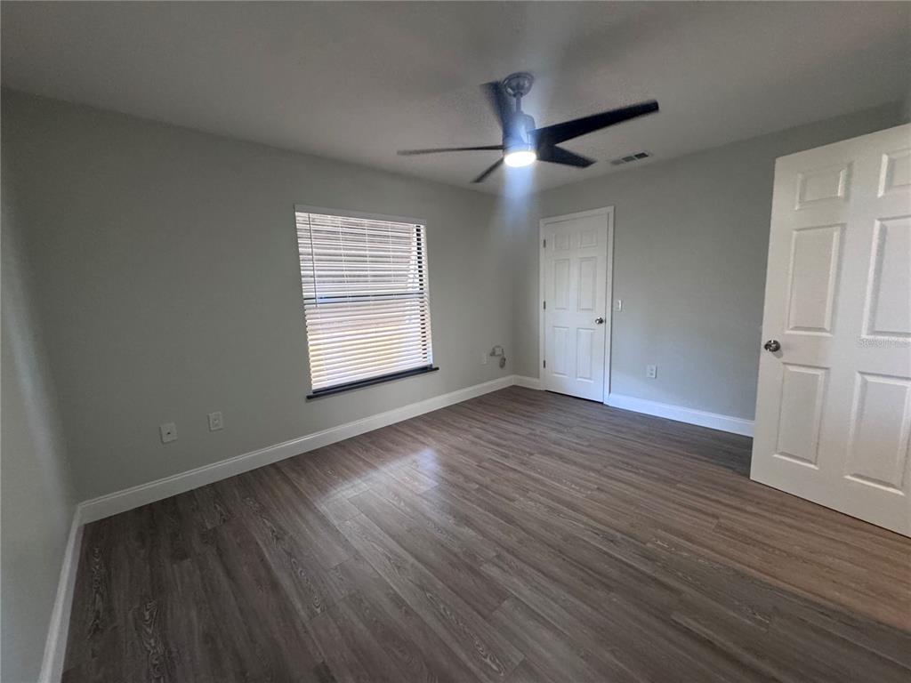 1755 Highland Road Osprey, FL 34229 - Photo 23 of 31 an empty room with wooden floor a ceiling fan and windows