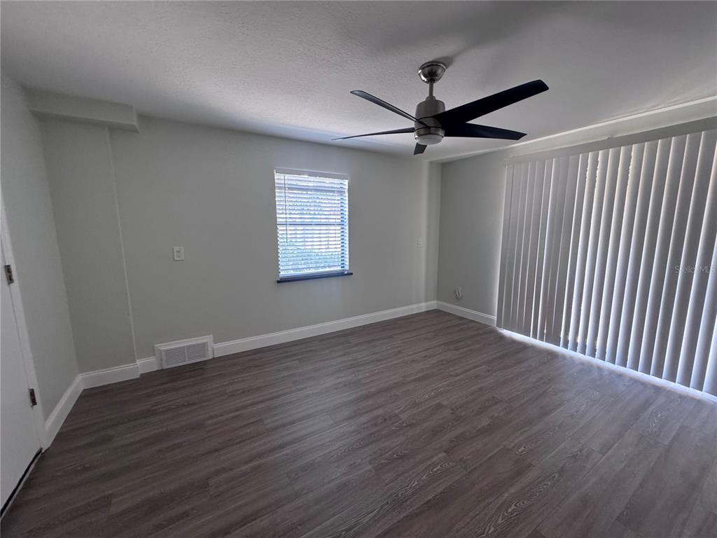 1755 Highland Road Osprey, FL 34229 - Photo 28 of 31 an empty room with wooden floor fan and windows