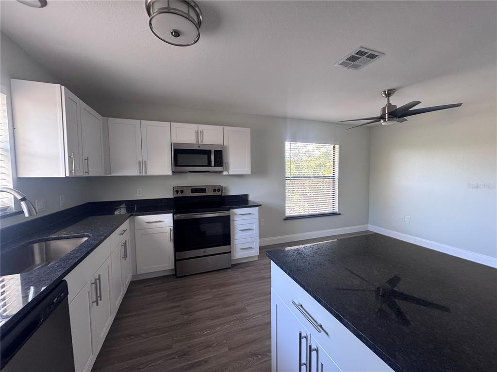 1755 Highland Road Osprey, FL 34229 - Photo 8 of 31 a kitchen with granite countertop a stove sink and microwave