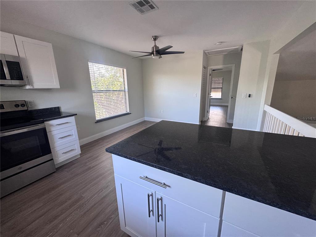 1755 Highland Road Osprey, FL 34229 - Photo 9 of 31 a kitchen with granite countertop a stove a sink and a microwave