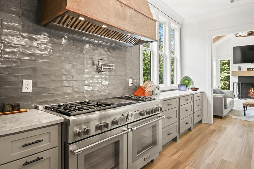 6014 Warpath Road Flowery Branch, GA 30542 - Photo 12 of 36 a kitchen with white cabinets and appliances