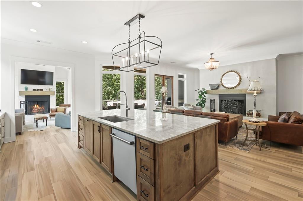 6014 Warpath Road Flowery Branch, GA 30542 - Photo 13 of 36 a hall with kitchen island a stove flat screen tv and wooden floor