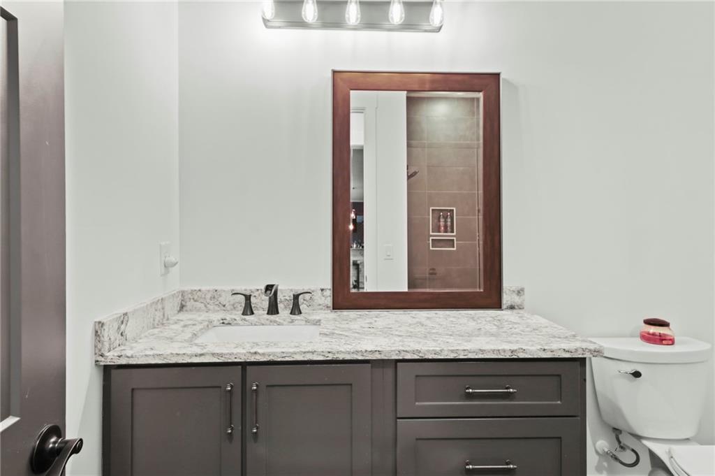 6014 Warpath Road Flowery Branch, GA 30542 - Photo 30 of 36 a bathroom with a granite countertop sink and a mirror