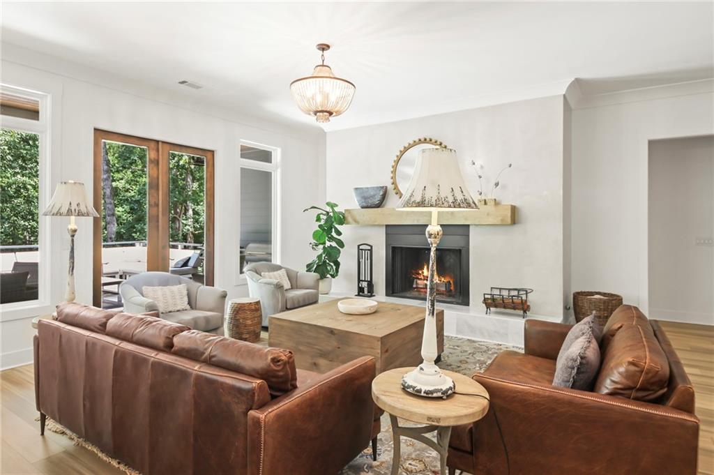 6014 Warpath Road Flowery Branch, GA 30542 - Photo 6 of 36 a living room with furniture a large window and a fireplace