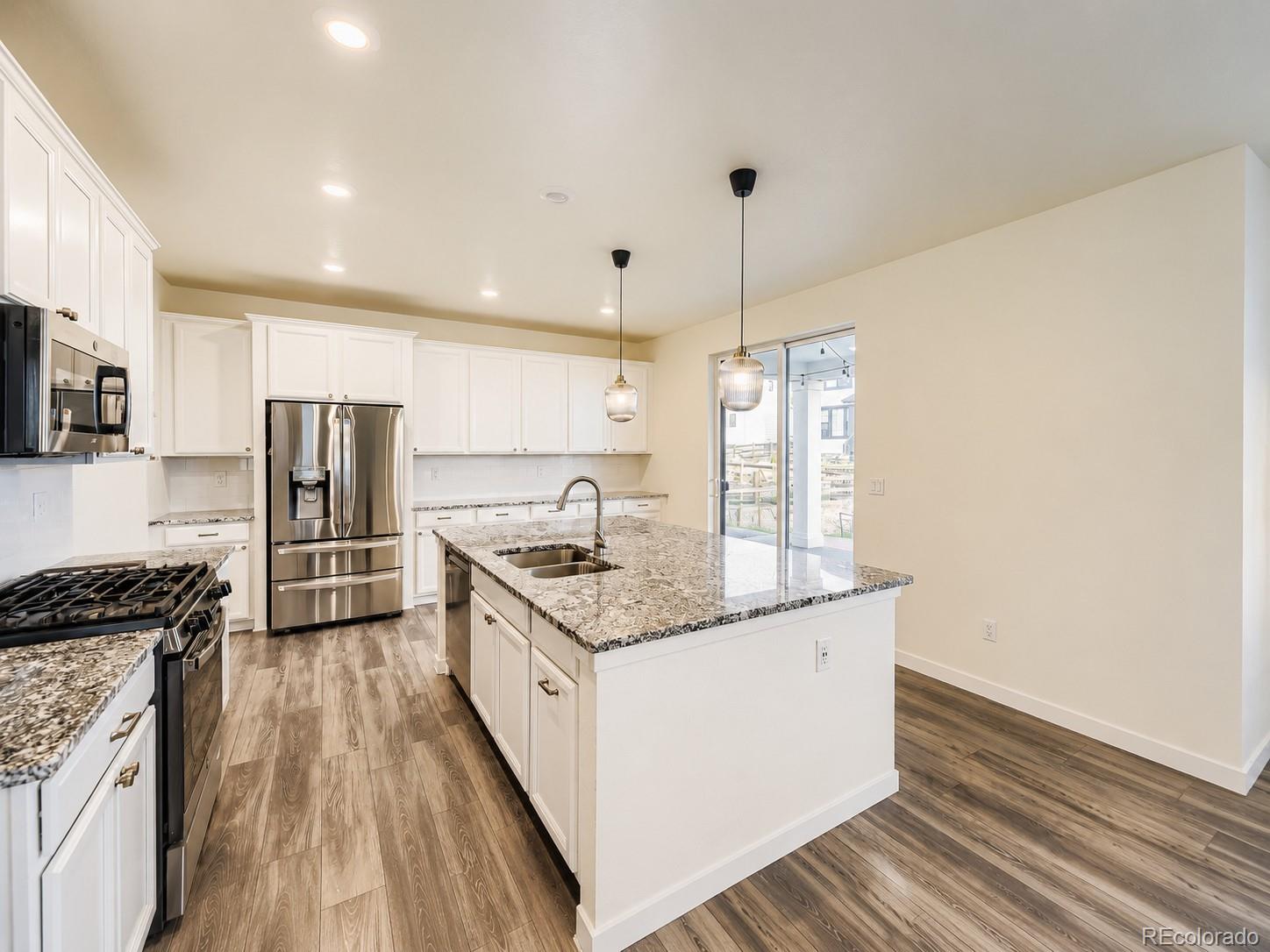 1173 Williams Loop Elizabeth, CO 80107 - Photo 7 of 30 a kitchen with stainless steel appliances granite countertop a sink stove and refrigerator
