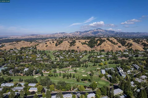 an aerial view of residential houses with outdoor space and trees