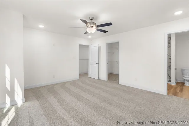 an empty room with closet and a ceiling fan
