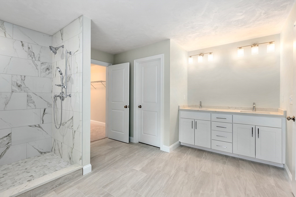 Lot 1 Quinn Road Marlborough, MA 01752 - Photo 21 of 26 a bathroom with a granite countertop sink mirror and a shower