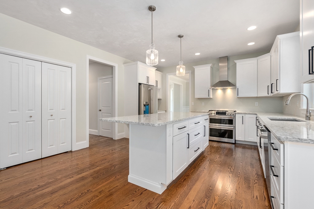 Lot 1 Quinn Road Marlborough, MA 01752 - Photo 10 of 26 a kitchen with stainless steel appliances granite countertop a sink a stove a refrigerator and white cabinets with wooden floor