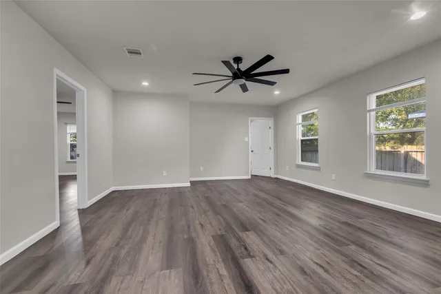 a view of empty room with wooden floor and window