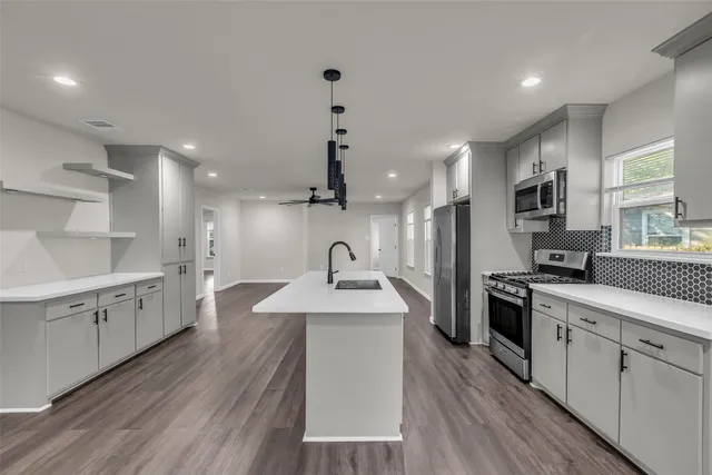 a kitchen with a sink stove cabinets and refrigerator