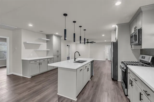 a kitchen with a sink stove and cabinets