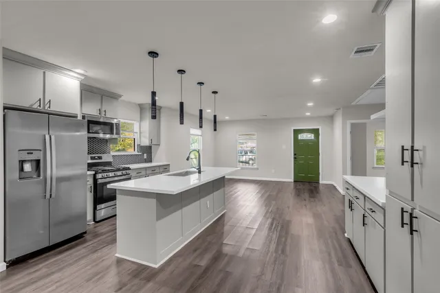 a kitchen with stainless steel appliances granite countertop a sink stove and refrigerator