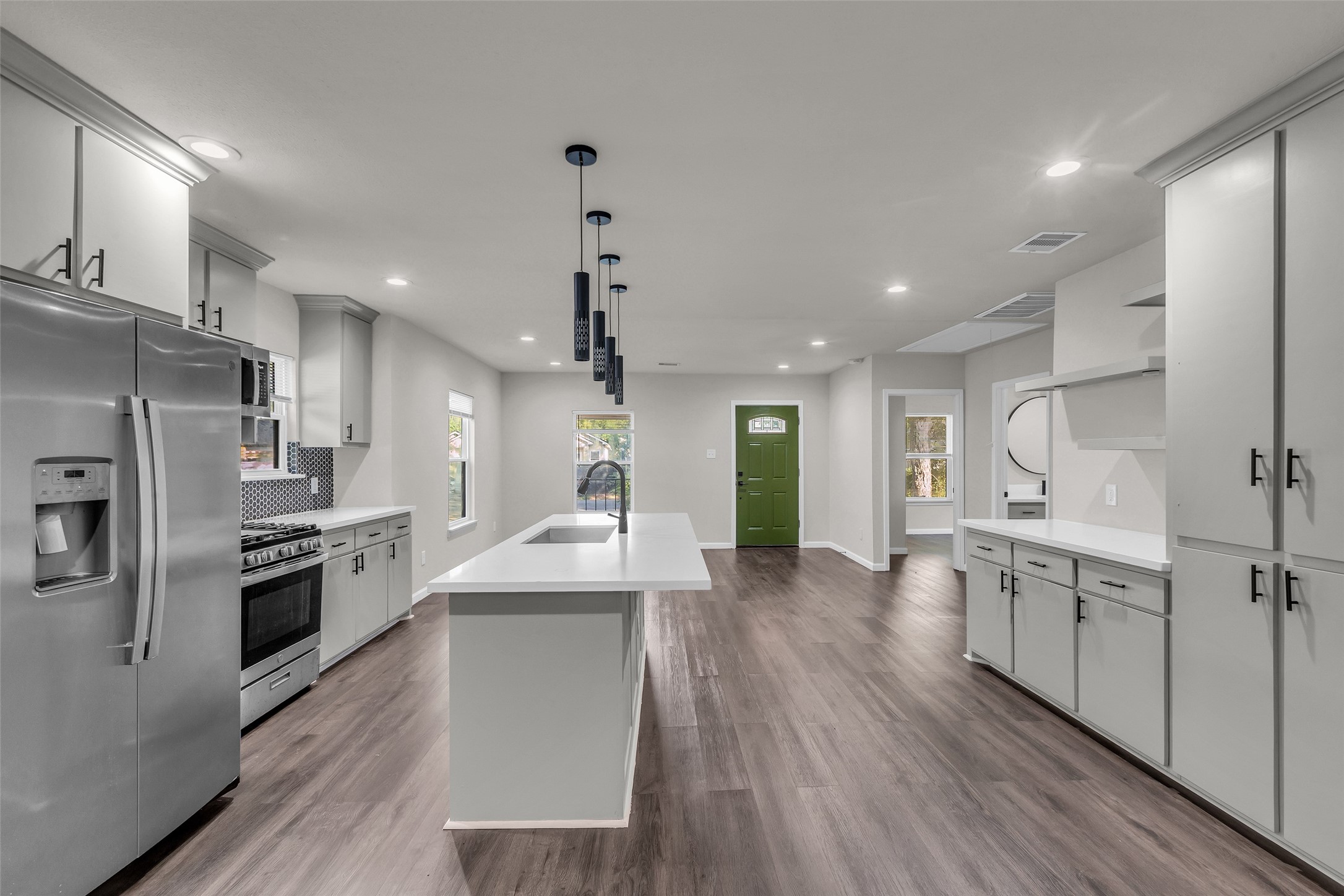 116 Gans Street Houston, TX 77029 - Photo 9 of 25 a large kitchen with stainless steel appliances kitchen island a large counter top and wooden floors