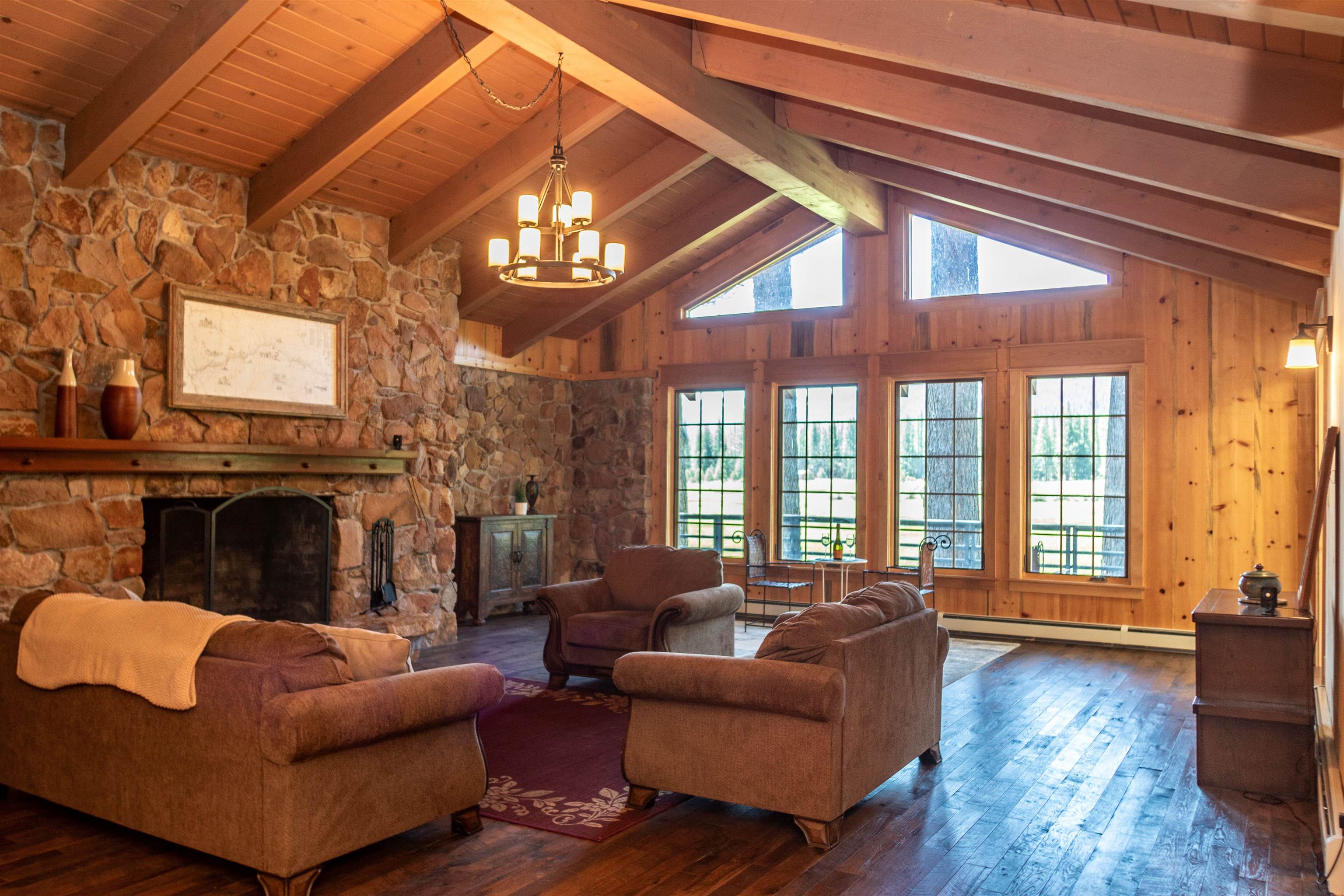300 Meadow Ranch Road Calpine, CA 96124 - Photo 20 of 21 a living room with furniture a fireplace and a dining table with wooden floor