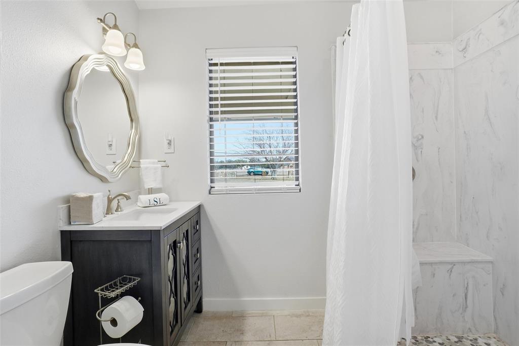 9501 Confederate Park Road Lakeside, TX 76135 - Photo 13 of 33 a bathroom with a toilet sink vanity and mirror