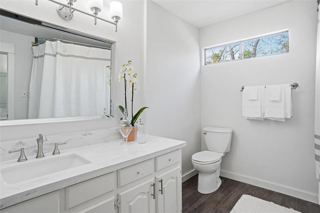 9501 Confederate Park Road Lakeside, TX 76135 - Photo 23 of 33 a bathroom with a granite countertop sink a toilet and a mirror