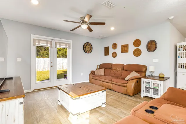 a living room with furniture flat screen tv and kitchen view