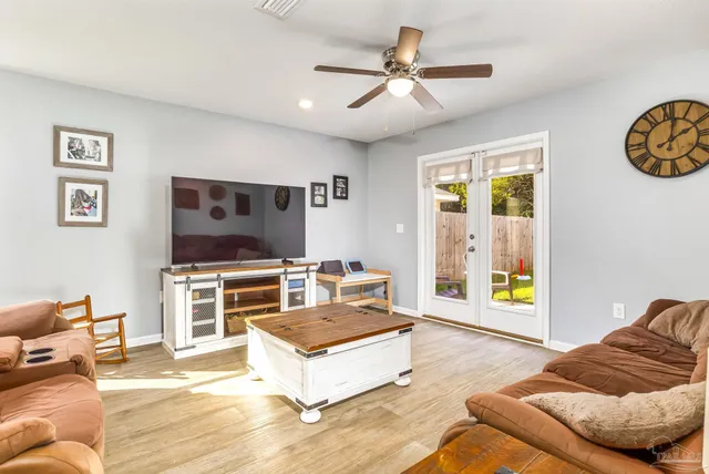 a living room with furniture and view of kitchen