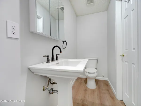 a bathroom with a sink toilet and a mirror