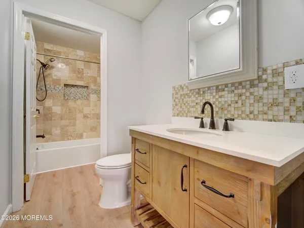 a bathroom with a sink a toilet and shower