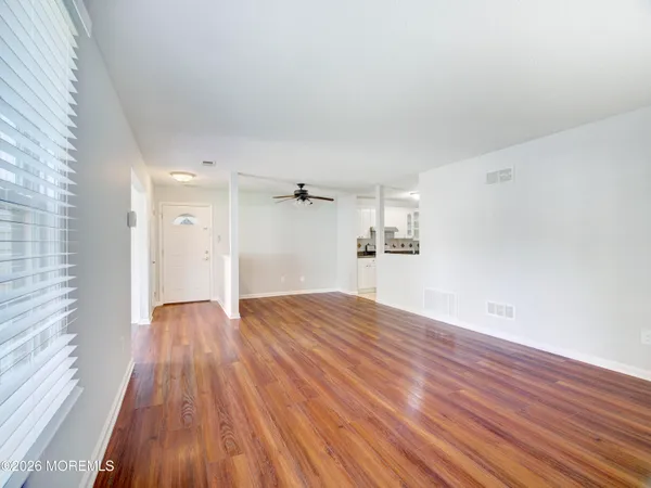 a view of empty room with wooden floor