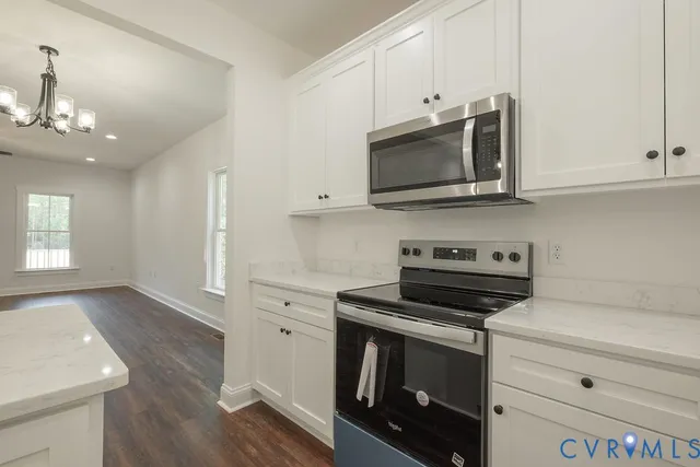 a kitchen with stainless steel appliances white cabinets and stove top oven