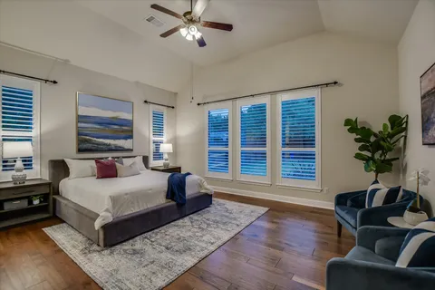 a bedroom with a large bed wooden floor and window