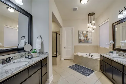 a bathroom with a granite countertop sink a large mirror and a bathtub