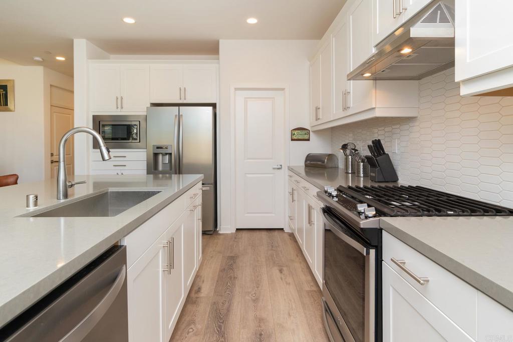 9056 Hightail Drive Santee, CA 92071 - Photo 12 of 73 a kitchen with stainless steel appliances granite countertop a sink stove and refrigerator