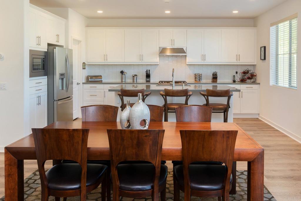 9056 Hightail Drive Santee, CA 92071 - Photo 15 of 73 a kitchen with stainless steel appliances a dining table chairs and a refrigerator