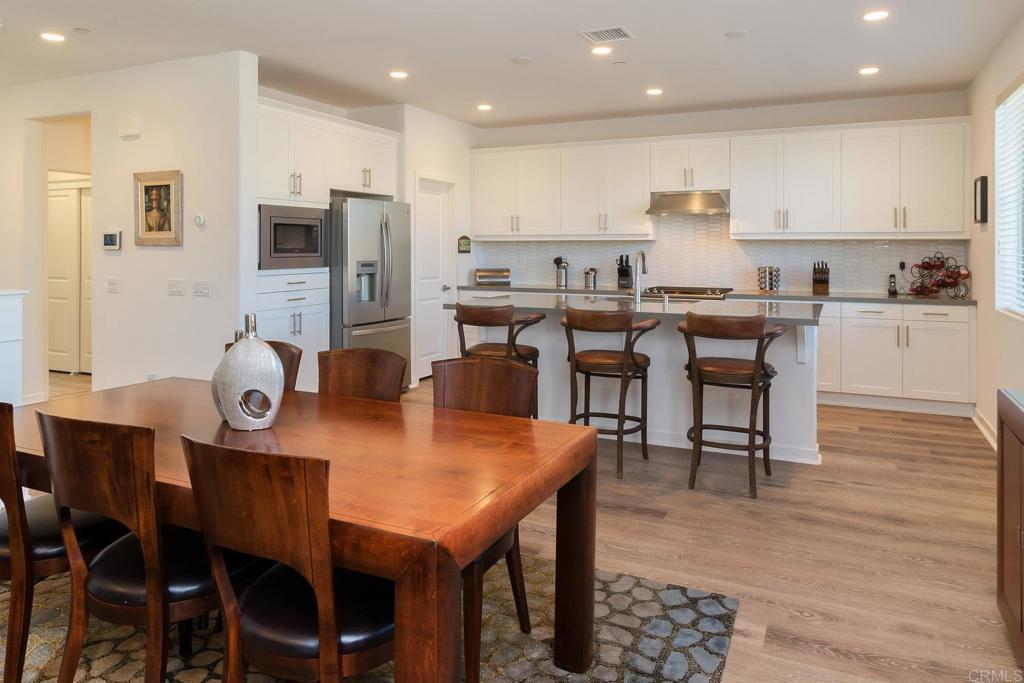9056 Hightail Drive Santee, CA 92071 - Photo 2 of 73 a open dining room with stainless steel appliances kitchen island granite countertop a dining table chairs and refrigerator