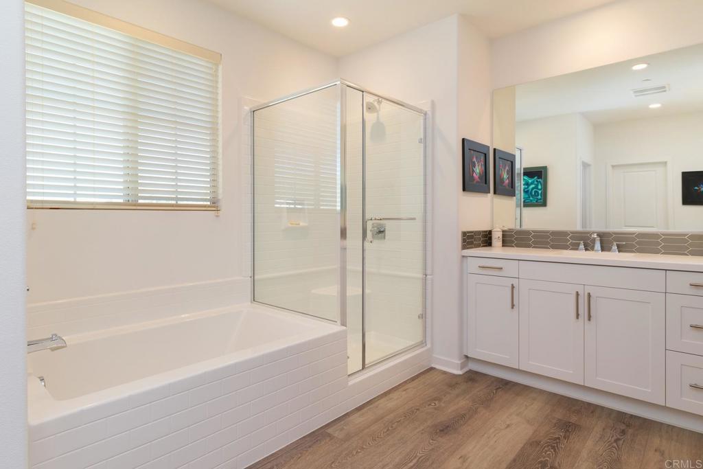 9056 Hightail Drive Santee, CA 92071 - Photo 23 of 73 a spacious bathroom with a granite countertop sink a mirror and a bathtub
