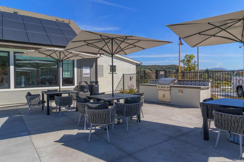 9056 Hightail Drive Santee, CA 92071 - Photo 44 of 73 a view of a patio with table and chairs under an umbrella
