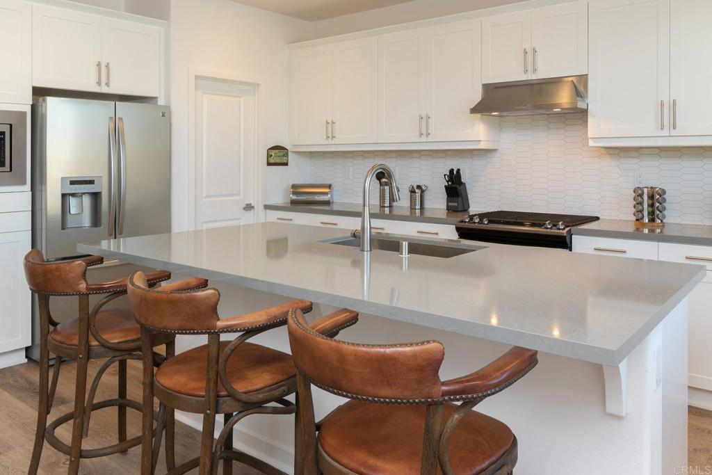 9056 Hightail Drive Santee, CA 92071 - Photo 10 of 73 a kitchen with stainless steel appliances granite countertop a table chairs sink and cabinets