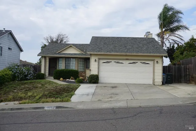 a front view of a house with a garden and garage
