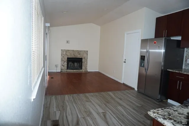 a view of a livingroom with wooden floor and a fireplace