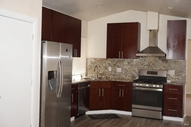 a kitchen with stainless steel appliances granite countertop a refrigerator and a stove