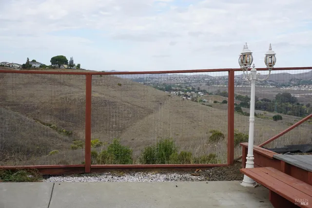 a view of backyard with wooden fence and large trees