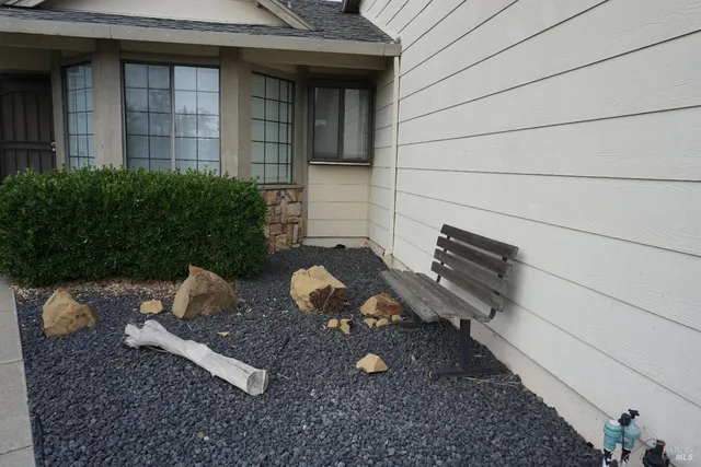 a view of a backyard with chairs and a grill