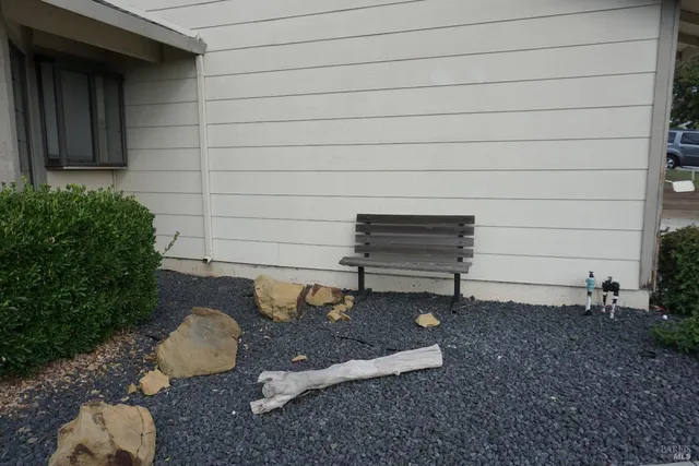 a view of a backyard with chairs and a bench