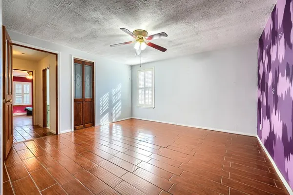 a view of an empty room with window and wooden floor