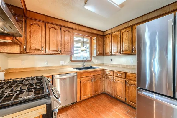 a kitchen with stainless steel appliances granite countertop a stove a sink and a refrigerator
