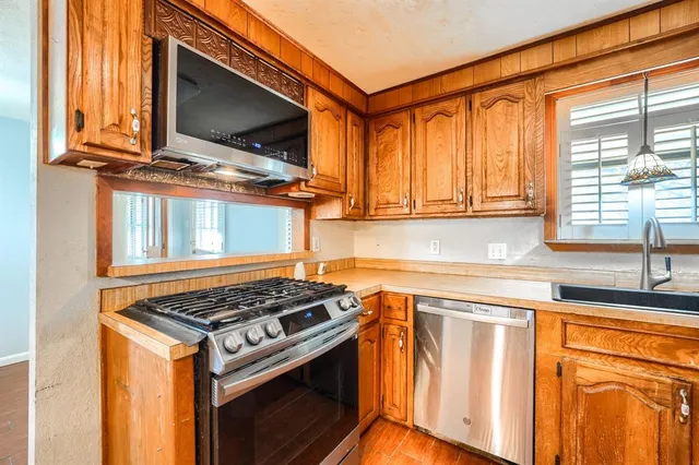 a kitchen with stainless steel appliances granite countertop a stove and a microwave