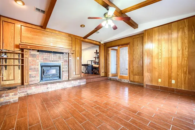 a view of an empty room with a fireplace and a window