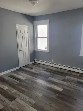 a view of a room with wooden floor and window