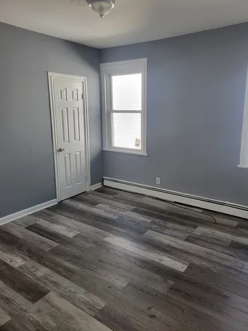 a view of a room with wooden floor and window